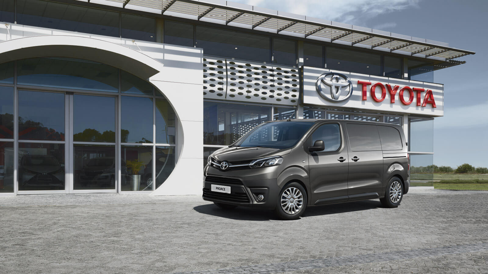 Vista lateral del Toyota ProAce aparcado junto a un concesionario Toyota